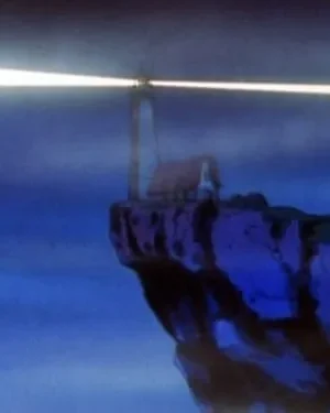 Farol em penhasco com feixe de luz brilhante, ao lado de uma casa, sob céu azul escuro. Cena noturna e misteriosa.