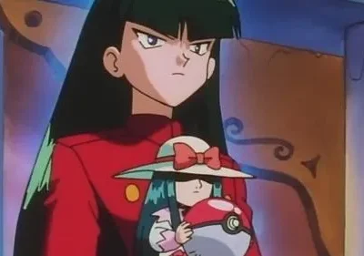 Mulher de anime com cabelo escuro e jaqueta vermelha, expressão séria, segurando uma boneca com chapéu e uma esfera vermelha e branca. Fundo escuro.