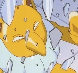 Criatura amarela de nariz grande, com pêndulo, rodeada por cacos de vidro flutuantes. Parece quebrando algo.