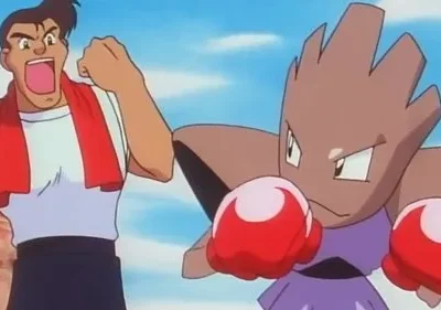 Homem musculoso grita para criatura marrom com luvas de boxe vermelhas, em pose de luta. Cenário exterior, céu azul. Clima de treino intenso.