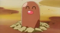Uma criatura marrom cilíndrica com nariz rosa e olhos fechados, sorrindo, emerge da terra em um cenário rochoso.
