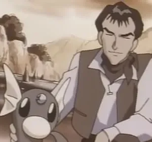 Foto de um homem de colete e camisa clara, com uma criatura cinza com barbatanas brancas. Fundo de montanhas e água. Cena serena.