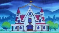 Casa animada branca com telhado vermelho e torres, decorada com banners, em dia chuvoso. Montanhas escuras ao fundo.