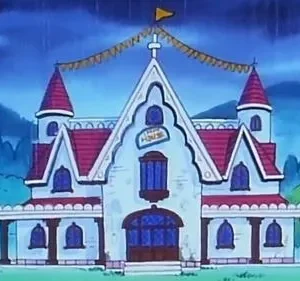 Casa animada branca com telhado vermelho e torres, decorada com banners, em dia chuvoso. Montanhas escuras ao fundo.