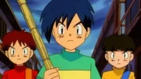 Três jovens de anime com expressões sérias em uma rua urbana. O central segura um bastão de bambu. Ambiente de determinação.