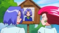 Personagem de cabelo roxo e um de cabelo vermelho chocados diante de cartaz de 'DESAPARECIDO' com foto do primeiro. Exterior.