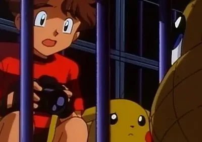 Criança com câmera atrás das grades olha surpresa para um monstro amarelo e um gigante marrom. Cena escura e tensa.