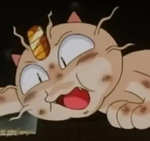 Criatura felina cor-de-areia suja, com uma moeda na testa, olhos arregalados e boca aberta, deitada exausta em chão escuro.