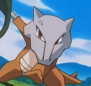 Criatura marrom com máscara de caveira cinza, segurando um objeto verde escuro. Em pose de ataque num campo gramado sob céu azul.