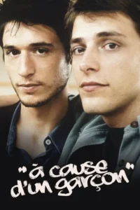 Close-up de dois jovens homens abraçados. Um tem barba por fazer e olha para frente, o outro mais limpo. Rostos sérios, clima íntimo.