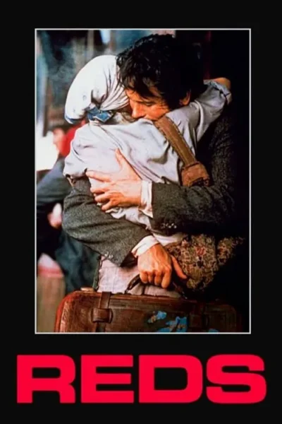 Duas pessoas se abraçam firmemente. Um homem de cabelo escuro segura uma mala, abraçando alguém com a cabeça coberta. Cena emotiva e dramática.