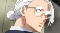 Close-up de perfil de personagem de anime masculino com cabelo branco em coque,óculos redondos e olhar atento.