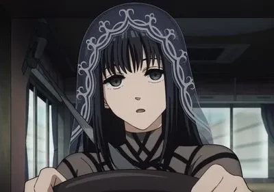 Mulher anime de cabelo preto e véu azul escuro detalhado. Ela usa blusa preta com tiras, dirigindo em veículo escuro, com olhar sério.