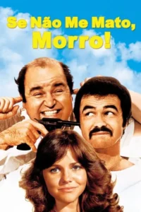 Três pessoas sorrindo contra céu azul. Homem careca com arma na boca e dedos nos ouvidos;outro homem com bigode olha para cima. Mulher sorri.