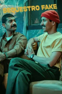 Dois homens com bigodes, um de marrom e outro de camiseta amarela e touca vermelha, conversam sorrindo em um cenário interno com tons azuis.