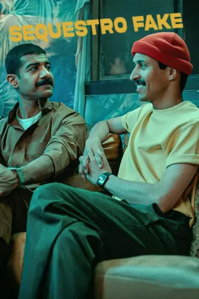 Dois homens com bigodes, um de marrom e outro de camiseta amarela e touca vermelha, conversam sorrindo em um cenário interno com tons azuis.