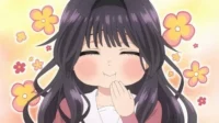 Jovem de anime sorri com bochechas rosadas e olhos fechados, mão no queixo, feliz. Fundo claro com flores coloridas.