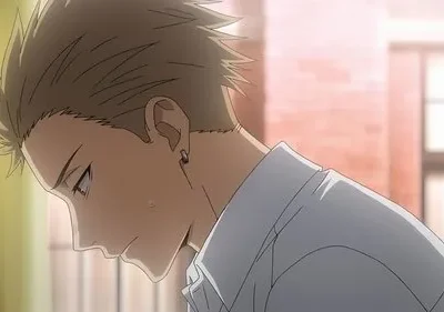 Jovem de anime com cabelo espetado e brinco, cabeça baixa e rosto levemente corado. Fundo desfocado com luz suave.