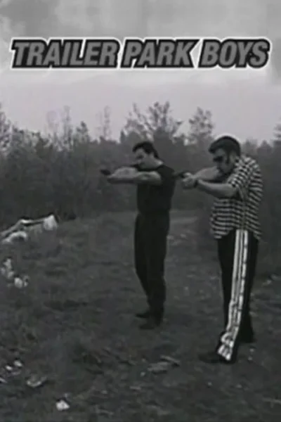 Dois homens em PB apontam pistolas num campo. Um veste camisa xadrez e calças de treino. Ambiente rural desordenado, clima de ação rústica.