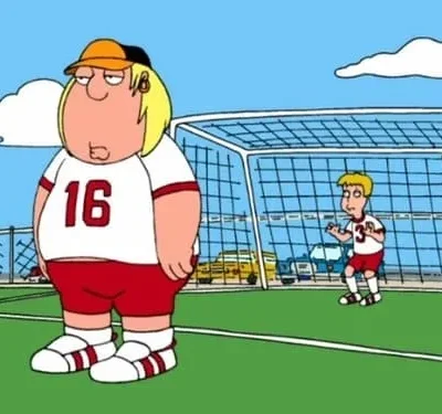 Dois personagens animados em um campo de futebol. Um homem grande de camisa 16, e um goleiro pequeno diante do gol. Céu azul ao fundo.