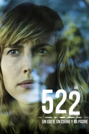 Close-up de mulher com cabelo ondulado e expressão séria, olhando através de vidro com reflexos azuis e verdes.