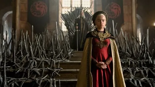 Jovem de vestido vermelho e capa dourada em salão real. Ao fundo, um trono de espadas com figura sentada e estandarte de dragão.