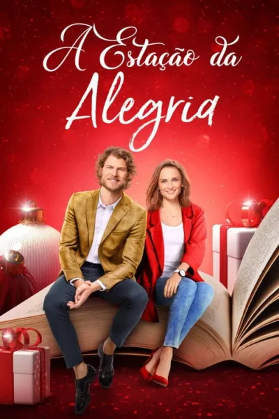 Casal sorridente sentado em livro aberto gigante, com fundo vermelho festivo e decorações de Natal.