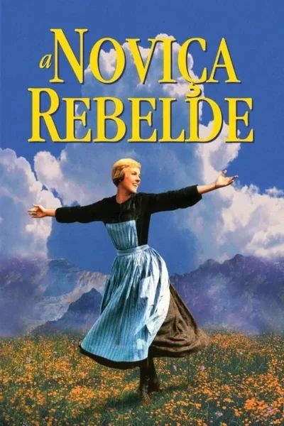 Mulher loira sorridente, de braços abertos, em campo florido sob montanhas e céu azul. Veste vestido azul. Clima alegre e livre.