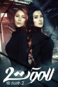 Duas mulheres, uma ruiva e uma morena, em blusas pretas. Seus cabelos estão unidos por uma trança. Fundo sombrio e industrial.