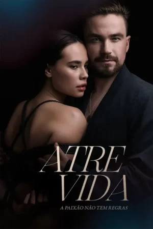 Um casal em close com fundo escuro. Ela, com cordas atadas ao corpo, é abraçada por ele que olha fixamente. Clima sensual e misterioso.