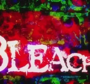 Texto branco e estilizado sobre fundo abstrato com manchas vibrantes em tons de vermelho, verde e azul. Clima caótico e energético.