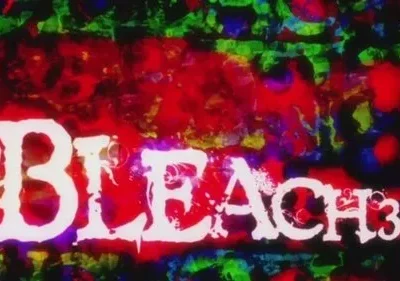 Texto branco e estilizado sobre fundo abstrato com manchas vibrantes em tons de vermelho, verde e azul. Clima caótico e energético.