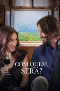 Mulher e homem sorrindo um para o outro em trem. Ela segura taça de vinho,ele barbudo. Vista de montanhas verdes pela janela.