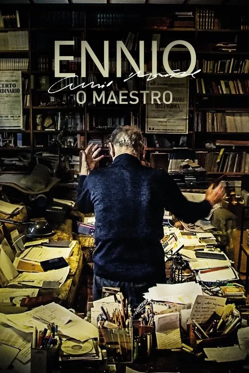 Um homem de costas gesticula intensamente em um estúdio cheio de livros e papéis. Clima de profundo processo criativo.