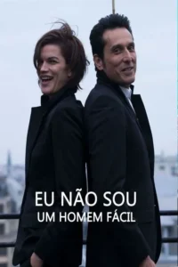 Mulher sorridente e homem sorridente,ambos de terno escuro,de costas um para o outro,em um telhado com vista urbana. Clima divertido.