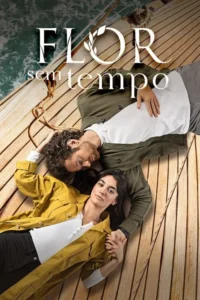 Casal deitado no convés de barco. Ela, de jaqueta amarela, e ele, de verde, de mãos dadas. Mar ao fundo. Clima romântico e pacífico.