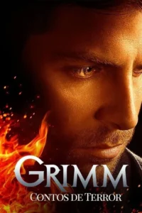 Um homem sério,com barba,é iluminado por chamas e faíscas. O fogo domina o lado esquerdo da imagem,criando um clima intenso.