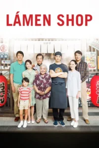 Nove pessoas, incluindo um chef e uma criança, sorriem em frente a um restaurante japonês. Clima familiar e acolhedor.