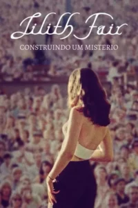Mulher de costas,cabelo escuro,em destaque contra uma multidão desfocada. Clima de performance e mistério.