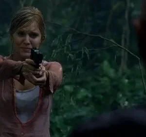 Mulher molhada com cabelo claro e rosto tenso aponta pistola para figura de costas numa floresta tropical chuvosa.