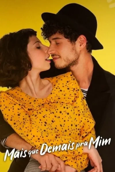 Jovem casal sorridente em fundo amarelo vibrante. Homem de chapéu e mulher de vestido estampado se abraçam, rostos próximos.