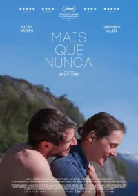 Homem e mulher sorrindo em abraço terno,com montanhas e céu azul ao fundo. Clima íntimo e sereno.
