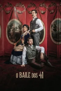 Três pessoas em trajes de época. Um homem de bigode em pé,uma mulher sentada em vestido azul,e outro homem no chão. Fundo vermelho detalhado.