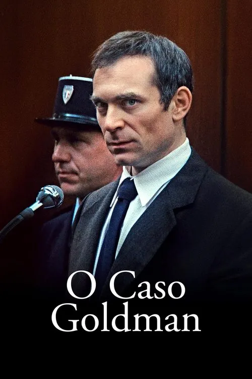O Caso Goldman 1 Homem de terno escuro olha intensamente. Um guarda e microfone atrás,sugerindo um ambiente de tribunal sombrio e tenso.