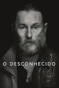 Homem barbudo de meia-idade,com olhar direto e intenso,em close-up. Pôster monocromático em tom sério e misterioso.