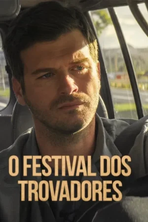 Homem barbudo de olhos azuis com expressão séria no carro. Luz solar no rosto, cenário externo desfocado ao fundo.