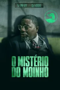 Homem de óculos e barba, com terno, olha aflito em ambiente escuro e cinza. Um relógio digital e um logo verde de pato são visíveis na parede.