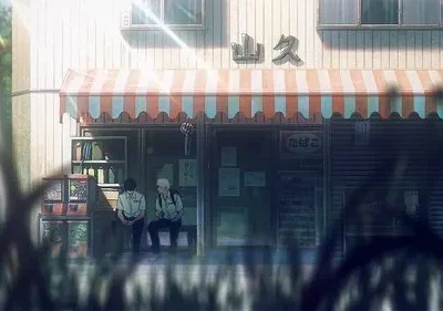 Dois jovens sentados em frente a uma loja japonesa com toldo listrado. Luz do sol e folhagem criam um clima quente e sereno.