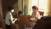 Um jovem e uma mulher sentados à mesa em um quarto banhado por luz dourada. Outra pessoa relaxa ao fundo, em um ambiente doméstico.