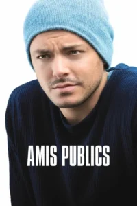 Close-up de um homem de gorro azul e camisa escura, com expressão séria e sobrancelhas franzidas, sobre fundo branco.